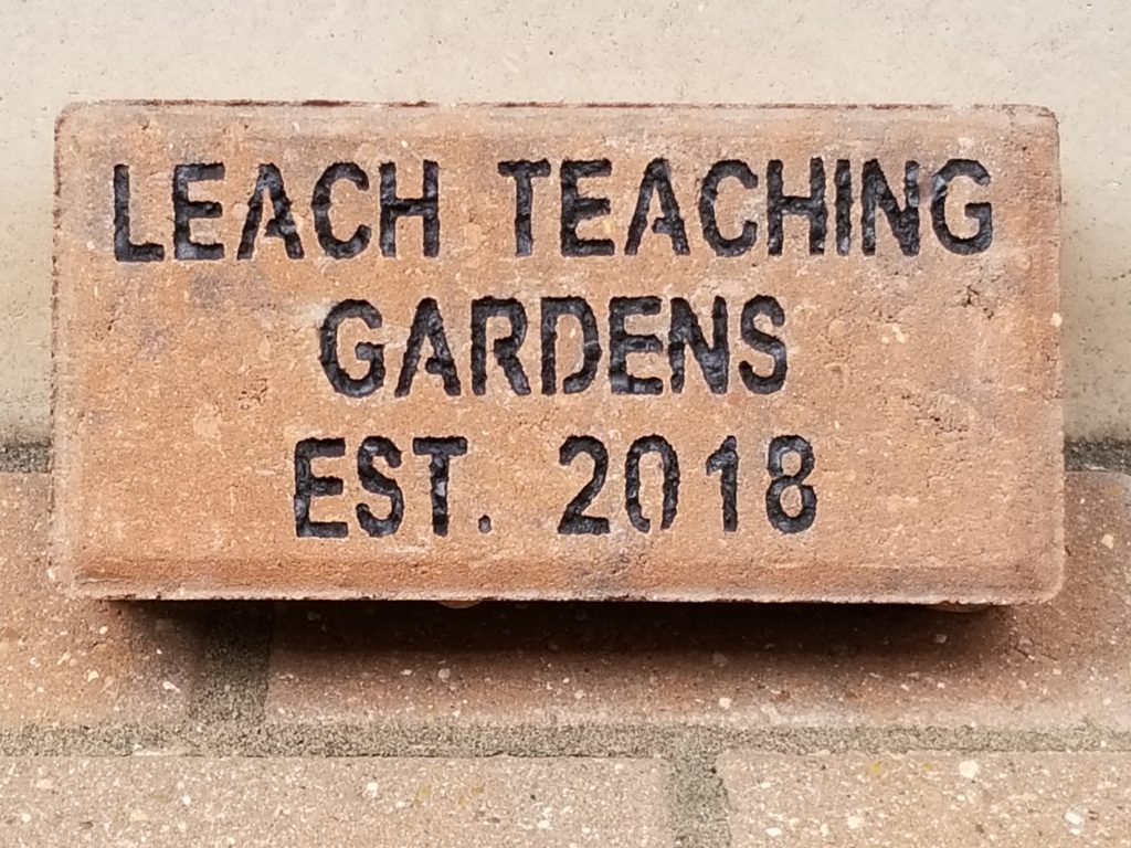 A brick with "Leach Teaching Gardens Est. 2018 engraved.